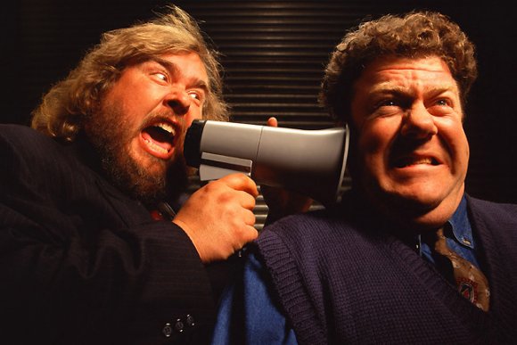 John Candy whispers something to George Wendt.